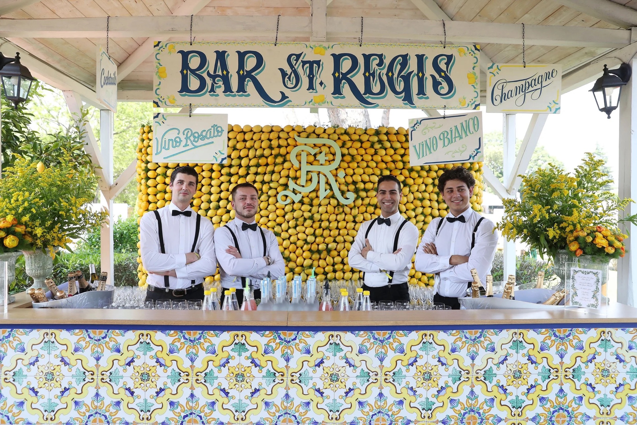A pop-up Bar St. Regis with bartenders behind a wall of lemons