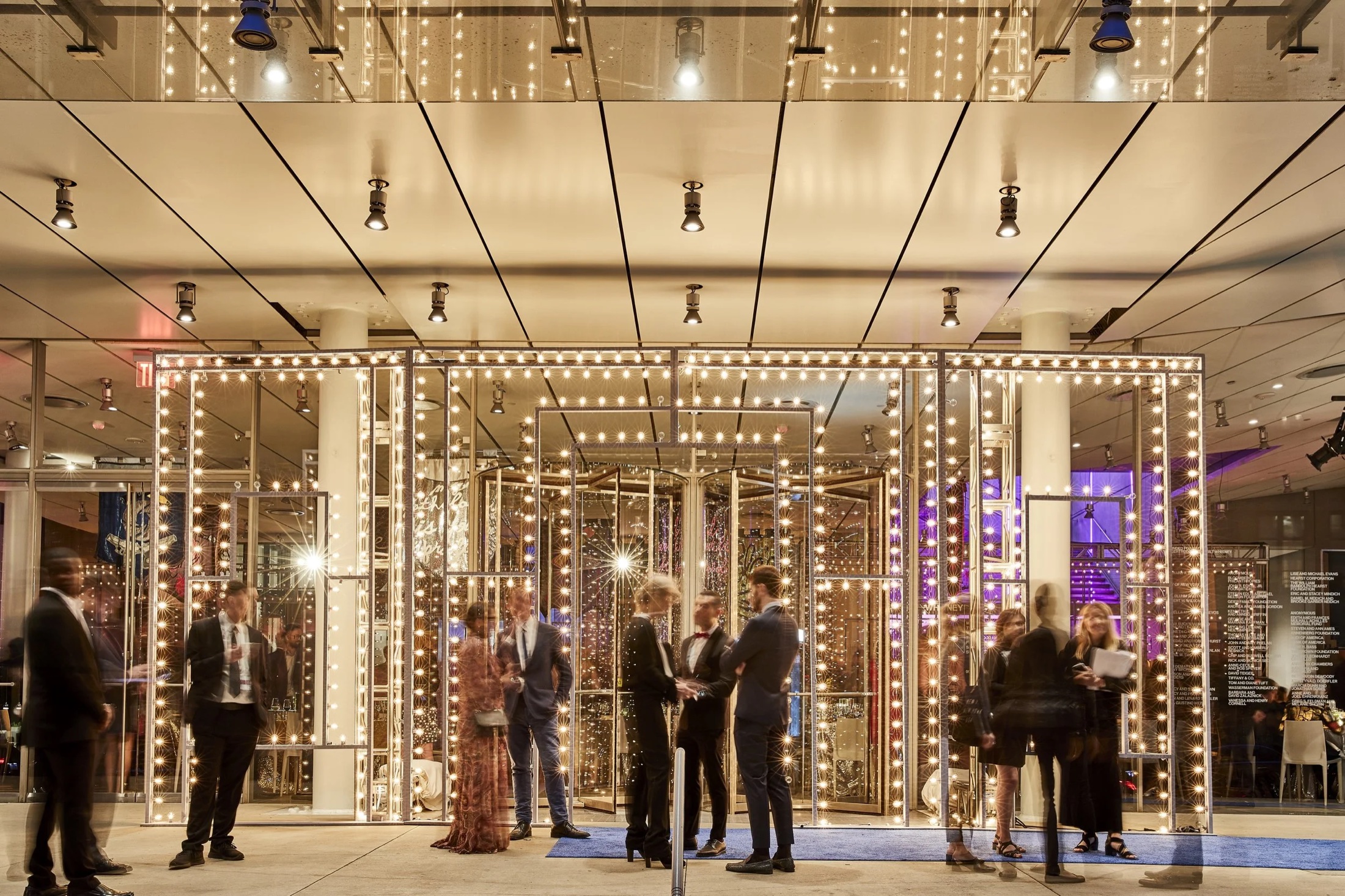 Guests among glowing light boxes at a gallery opening