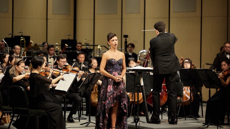A soloist with an orchestra on a concert stage